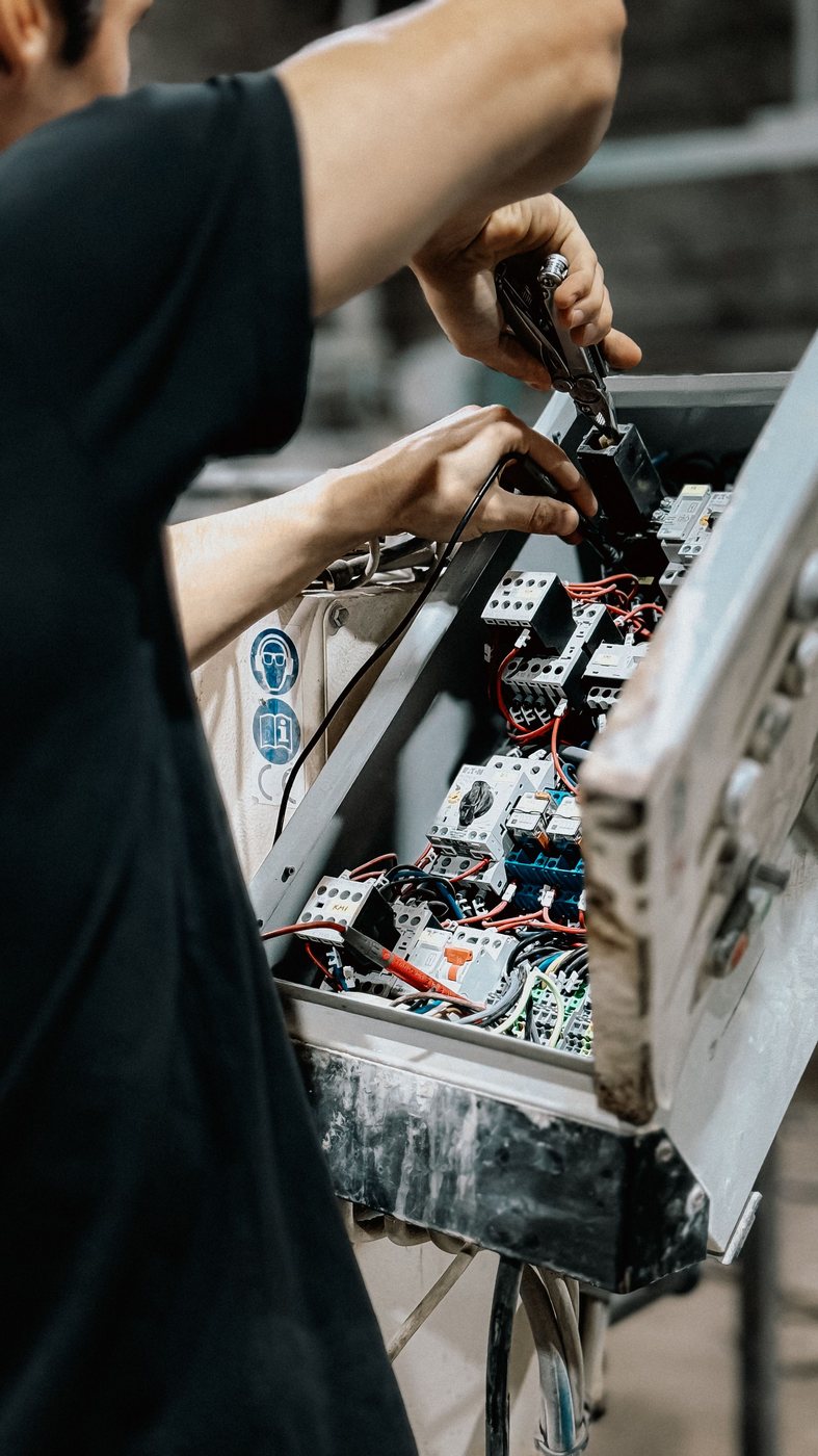 Technician working inside an electrical control panel